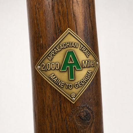 2,000 Miler hiking stick medallion installed on a wooden hiking staff