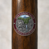 Box Canyon Falls Park hiking stick medallion installed on a wooden hiking staff