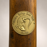 Wekiwa Springs State Park hiking stick medallion installed on a wooden hiking staff