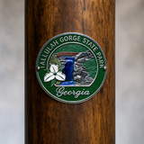 Tallulah Gorge State Park hiking stick medallion installed on a wooden hiking staff