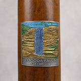 Toccoa Falls hiking stick medallion installed on a wooden hiking staff